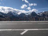 a road with no cars near the top and snowy mountain in the background during the day