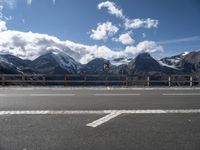 a road with no cars near the top and snowy mountain in the background during the day