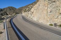 the curved road is very empty in its natural habitat as well as mountains on either side