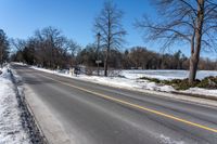 a road is empty in winter and the road is cleared off from snow and ice