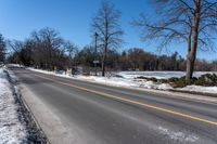 a road is empty in winter and the road is cleared off from snow and ice