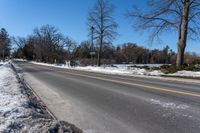 a road is empty in winter and the road is cleared off from snow and ice