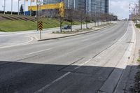 an empty road with some buildings and flags on the sidewalk nearby it are also in the distance