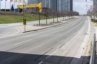 an empty road with some buildings and flags on the sidewalk nearby it are also in the distance