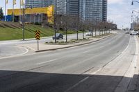 an empty road with some buildings and flags on the sidewalk nearby it are also in the distance