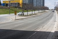 an empty road with some buildings and flags on the sidewalk nearby it are also in the distance