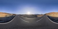 an empty road with some mountains and a sun rising in the background a picture of an empty road with many mountains and a sun rise up at the bottom,