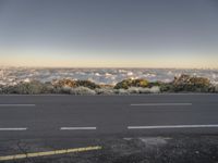 the road is empty with cars and clouds in the distance on the horizon on the other side