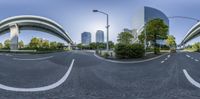 an empty street lined with tall buildings and trees in the middle of it with no traffic