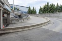 an empty road is lined with concrete steps and concrete ramps between two cement wall buildings