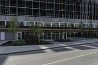 an empty road on a city street, with tall buildings behind it with no people