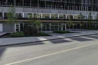 an empty road on a city street, with tall buildings behind it with no people