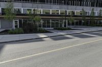 an empty road on a city street, with tall buildings behind it with no people