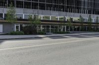 an empty road on a city street, with tall buildings behind it with no people