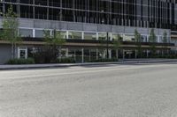 an empty road on a city street, with tall buildings behind it with no people