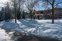 an empty road with the shadows on the snowbank on either side of the street