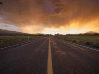 an empty road with a yellow line at sunset in a rural setting on the horizon