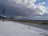 there is an empty road beside a mountainside, with a mountain in the distance