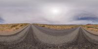 a view of an empty desert road in the daytime sunlight - colored photo by the lens of the panorama camera