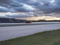 the road between two rows is empty during a cloudy day in the nascar stadium's parking lot