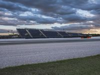 the road between two rows is empty during a cloudy day in the nascar stadium's parking lot