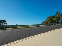 an empty road near the woods and blue skys on a clear day in australia