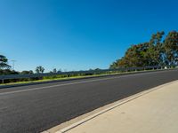 an empty road near the woods and blue skys on a clear day in australia