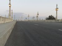 the empty roadway of an interstate between city and airport skies at dusk with traffic lights