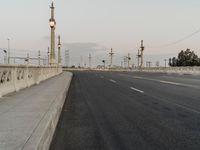 the empty roadway of an interstate between city and airport skies at dusk with traffic lights