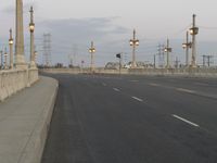 the empty roadway of an interstate between city and airport skies at dusk with traffic lights