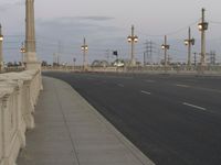 the empty roadway of an interstate between city and airport skies at dusk with traffic lights