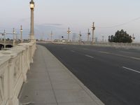 the empty roadway of an interstate between city and airport skies at dusk with traffic lights