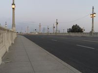 the empty roadway of an interstate between city and airport skies at dusk with traffic lights