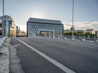 there is an empty roadway near an office building on the other side of the street