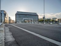 there is an empty roadway near an office building on the other side of the street