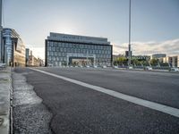 there is an empty roadway near an office building on the other side of the street