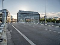 there is an empty roadway near an office building on the other side of the street