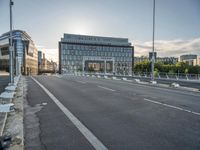 there is an empty roadway near an office building on the other side of the street