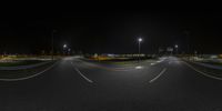 a curve in an empty roadway at night time with street lights on both sides of it