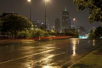 a view of an empty roadway at night in the city skyline with cars going by