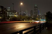 a view of an empty roadway at night in the city skyline with cars going by