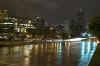 a view of an empty roadway at night in the city skyline with cars going by