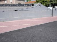 the empty roadway is painted gray in color and bricks on the walls are lined with black tiles