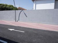 the empty roadway is painted gray in color and bricks on the walls are lined with black tiles