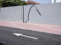 the empty roadway is painted gray in color and bricks on the walls are lined with black tiles