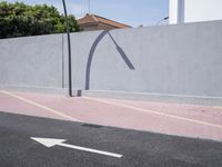 the empty roadway is painted gray in color and bricks on the walls are lined with black tiles