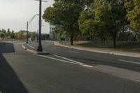 the empty roadway is empty at the end of the day with street lamps on the corner