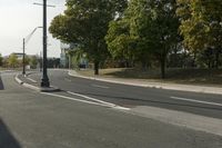 the empty roadway is empty at the end of the day with street lamps on the corner