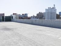 an empty parking lot on the rooftop of a building near a city skyline with skyscrapers