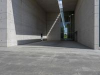 a empty room with a concrete wall and a red fire hydrant in it, as the sun shines on the stone floor